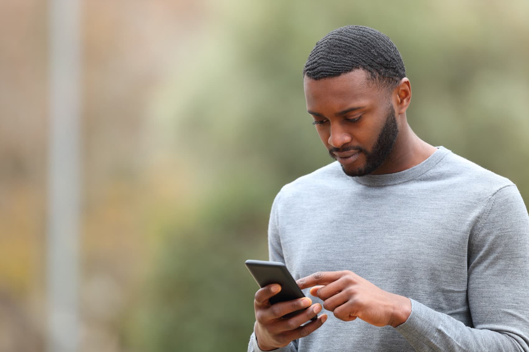 A person reading a message from their church on their phone outdoors